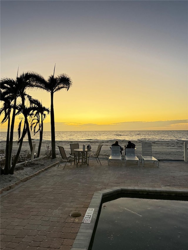 patio terrace at dusk featuring a water view