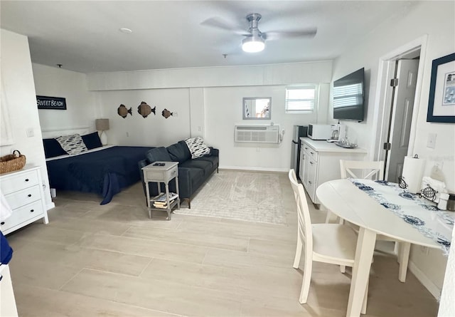 interior space featuring light wood finished floors, a wall mounted AC, and a ceiling fan