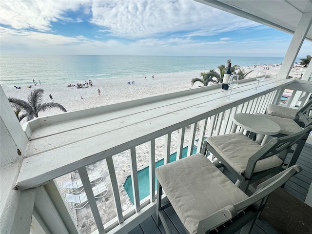 balcony featuring a water view and a view of the beach