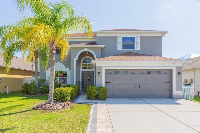 traditional-style house featuring stucco siding, a garage, concrete driveway, and a front yard