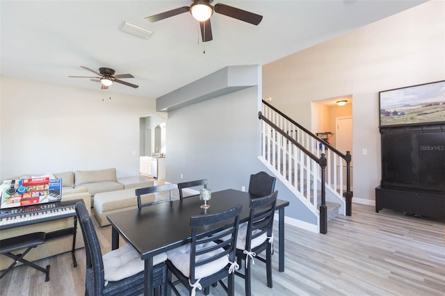 dining space with visible vents, wood finished floors, and a ceiling fan