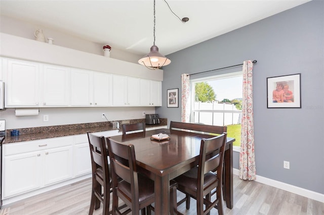 dining area featuring baseboards and light wood-type flooring