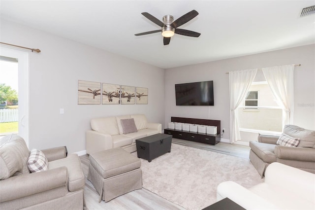 living area featuring visible vents, baseboards, wood finished floors, and a ceiling fan