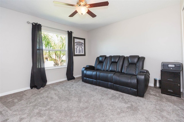 carpeted living area featuring a ceiling fan and baseboards