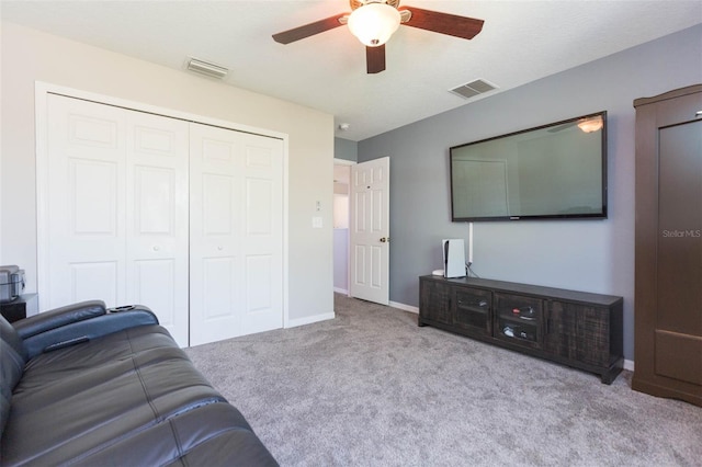 carpeted living area with a ceiling fan, visible vents, and baseboards