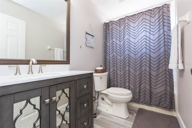 bathroom with curtained shower, toilet, vanity, and wood finished floors