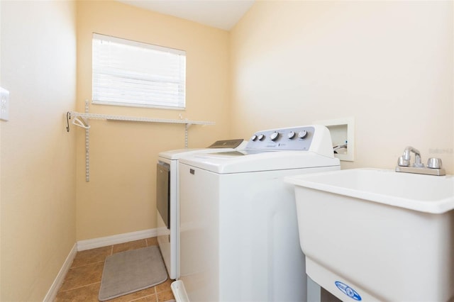 laundry area with tile patterned flooring, baseboards, laundry area, washer and dryer, and a sink