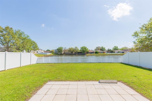 view of yard with a water view, a patio, and a fenced backyard