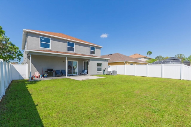 rear view of house with a patio area, a lawn, a fenced backyard, and stucco siding