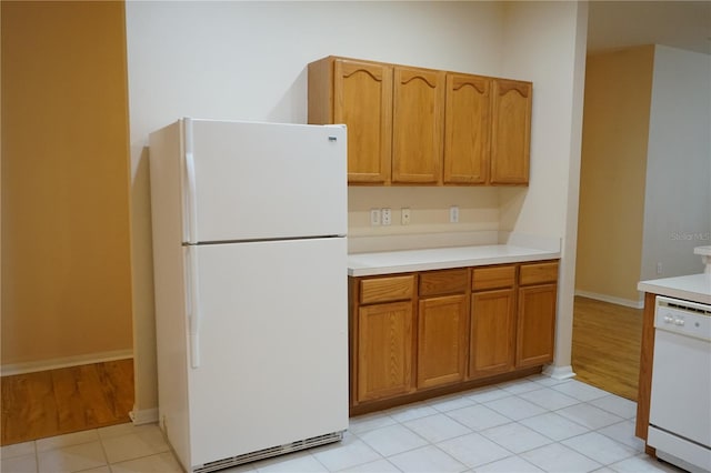 19432 Haskell Pl, Land O Lakes, FL 34638 - kitchen with white appliances, light countertops, brown cabinetry, and light tile patterned floors