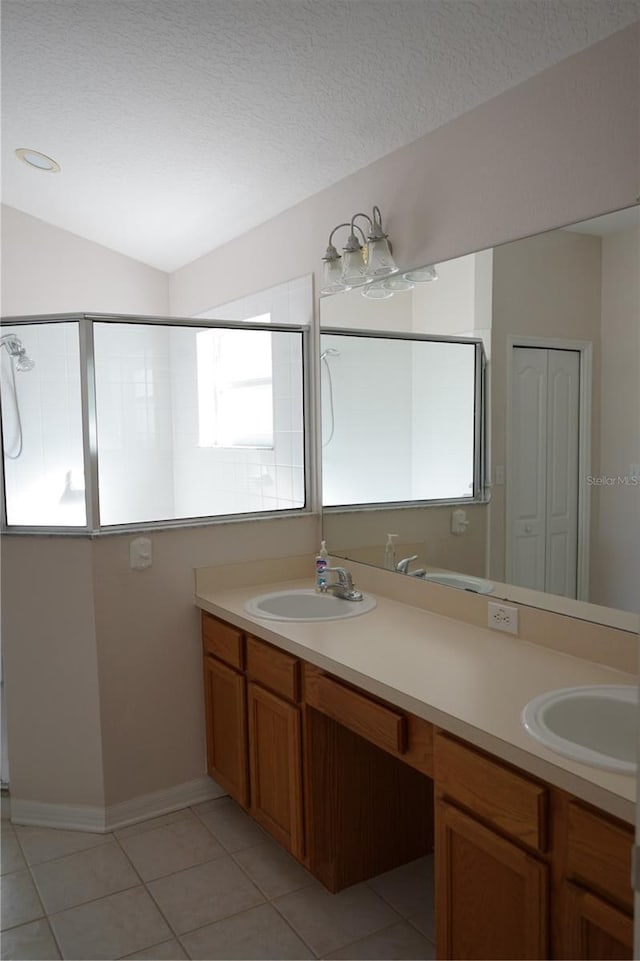 19432 Haskell Pl, Land O Lakes, FL 34638 - bathroom with double vanity, tile patterned flooring, a textured ceiling, a shower, and lofted ceiling