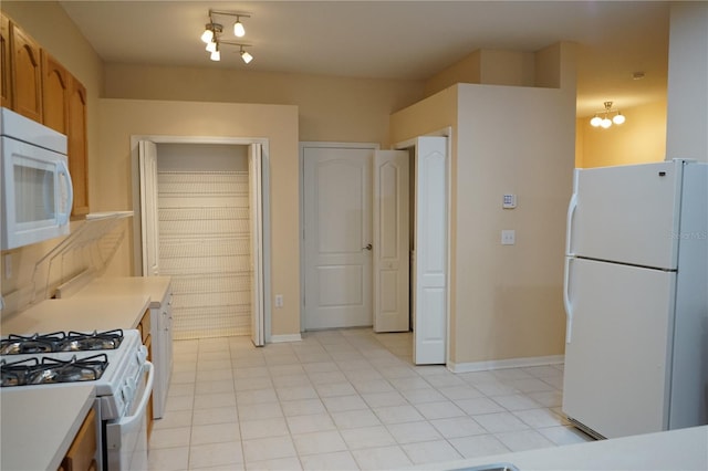 19432 Haskell Pl, Land O Lakes, FL 34638 - kitchen with white appliances, light countertops, light tile patterned floors, and brown cabinets