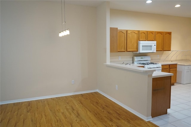 19432 Haskell Pl, Land O Lakes, FL 34638 - kitchen with white appliances, light countertops, recessed lighting, a peninsula, and light wood-style flooring