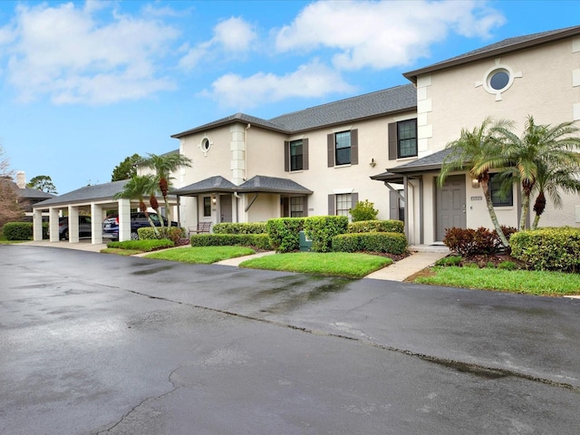 townhome / multi-family property featuring covered parking and stucco siding