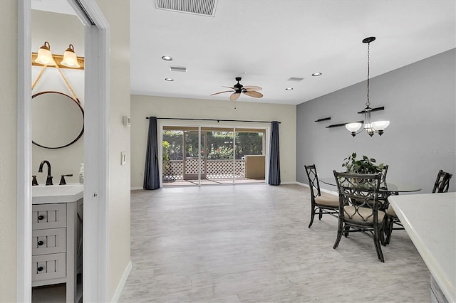 dining space featuring light wood-style floors, visible vents, and baseboards