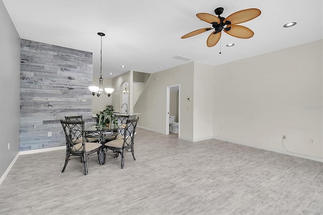 dining area featuring light wood-type flooring, an accent wall, baseboards, and recessed lighting