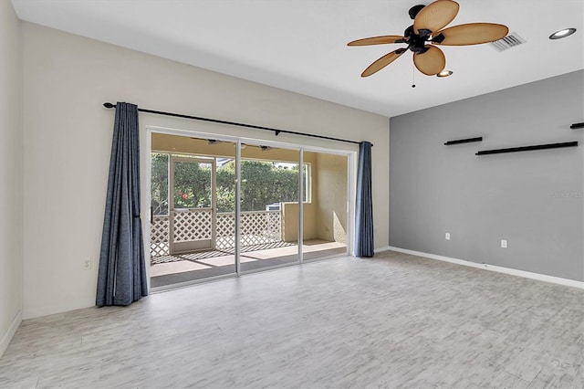 spare room featuring light wood-style floors, ceiling fan, visible vents, and baseboards