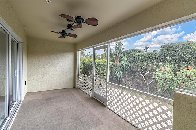 unfurnished sunroom with ceiling fan