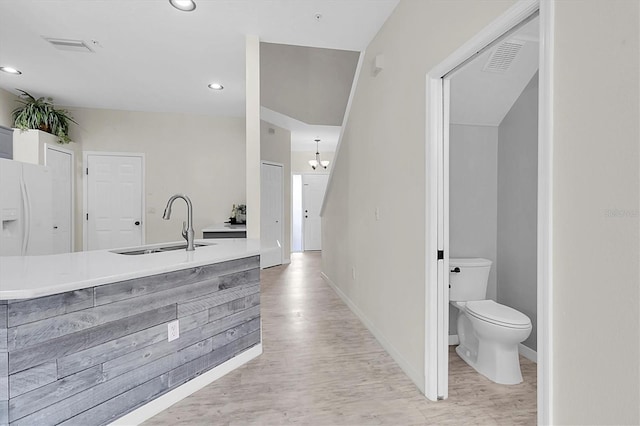 bathroom with toilet, recessed lighting, wood finished floors, a sink, and baseboards