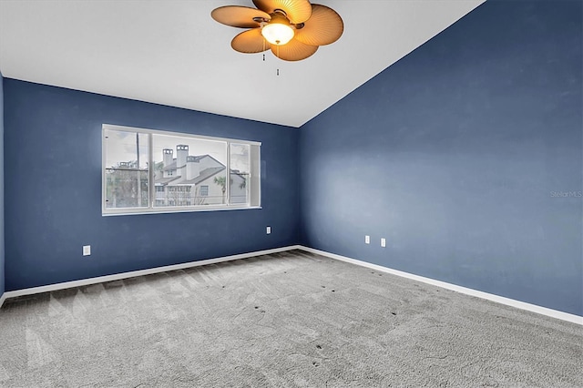 carpeted empty room featuring a ceiling fan, lofted ceiling, and baseboards