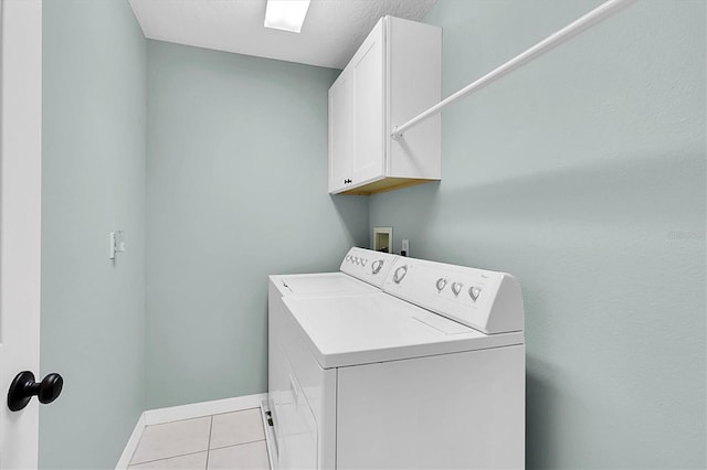 clothes washing area with cabinet space, baseboards, light tile patterned floors, and washer / clothes dryer
