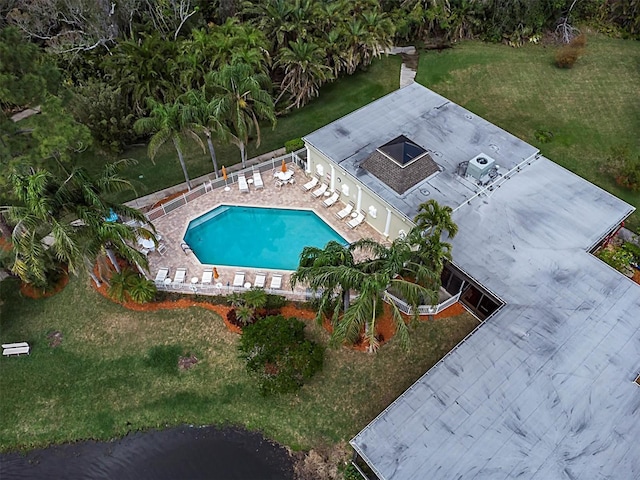 pool with a patio, a lawn, and fence