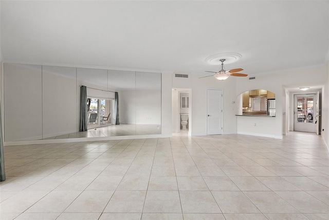 1200 N Shore Dr NE Unit 102, Saint Petersburg, FL 33701 - unfurnished living room featuring light tile patterned floors, arched walkways, a ceiling fan, and baseboards