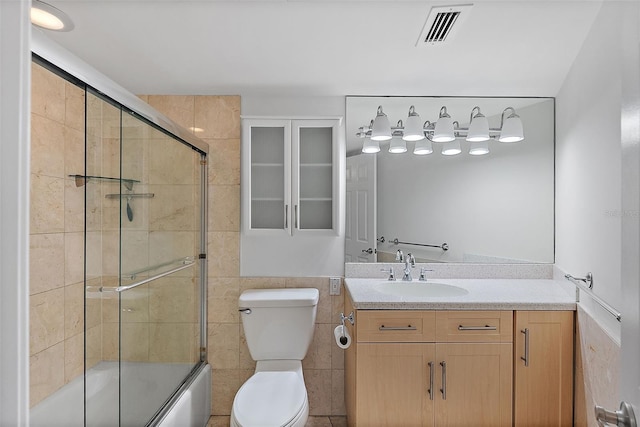 1200 N Shore Dr NE Unit 102, Saint Petersburg, FL 33701 - full bathroom featuring shower / bath combination with glass door, tile walls, visible vents, toilet, and vanity