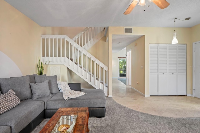 living room featuring ceiling fan, light carpet, visible vents, baseboards, and stairway