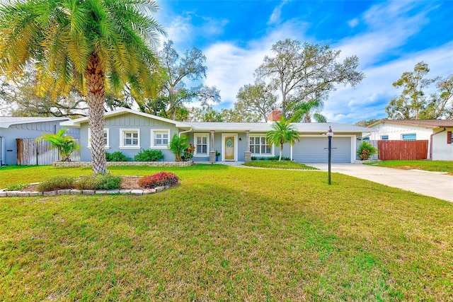 ranch-style home featuring an attached garage, fence, concrete driveway, a front lawn, and a chimney