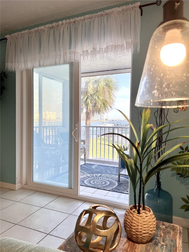 8901 Blind Pass Rd Unit 224, St Pete Beach, FL 33706 - doorway with light tile patterned flooring, plenty of natural light, and baseboards