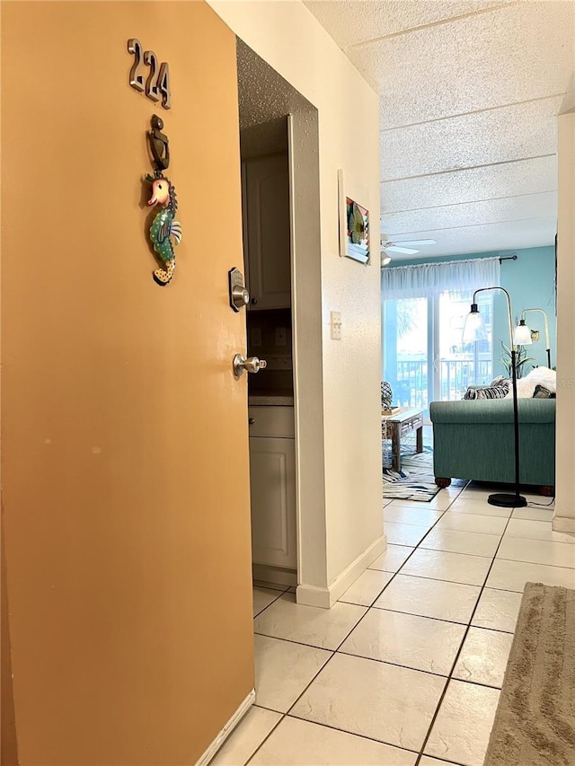 8901 Blind Pass Rd Unit 224, St Pete Beach, FL 33706 - hall with light tile patterned flooring, a textured ceiling, and baseboards