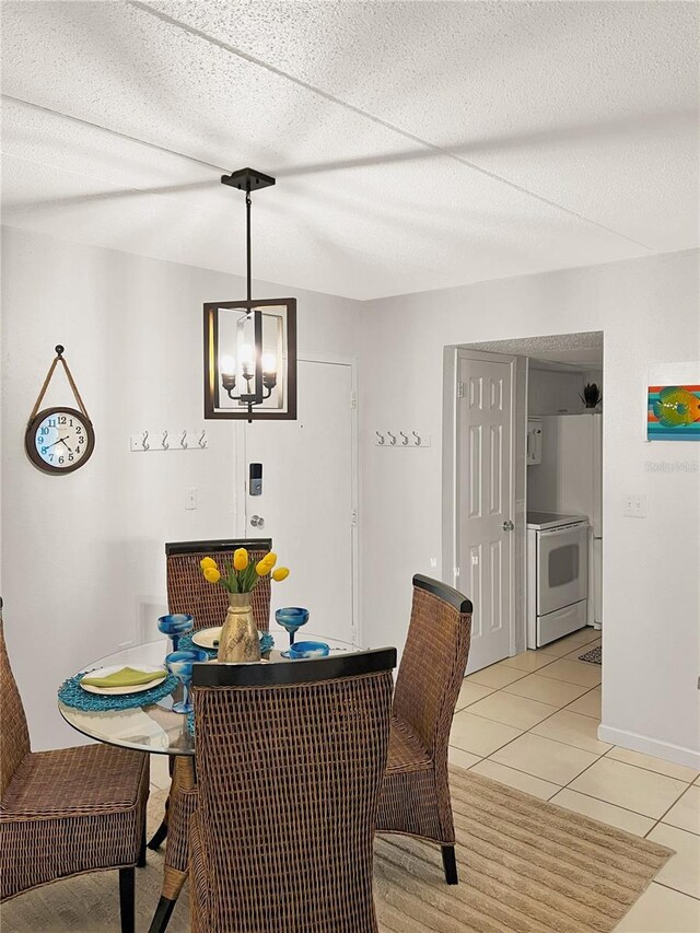 8901 Blind Pass Rd Unit 224, St Pete Beach, FL 33706 - dining area featuring light tile patterned floors, baseboards, and a chandelier