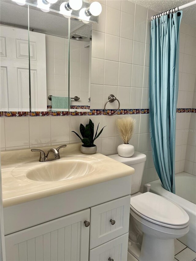 8901 Blind Pass Rd Unit 224, St Pete Beach, FL 33706 - bathroom featuring tile walls, vanity, shower / bath combo, and toilet