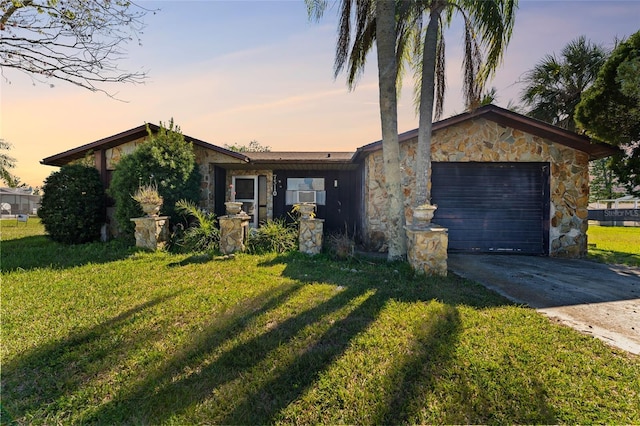 ranch-style house featuring a yard and a garage