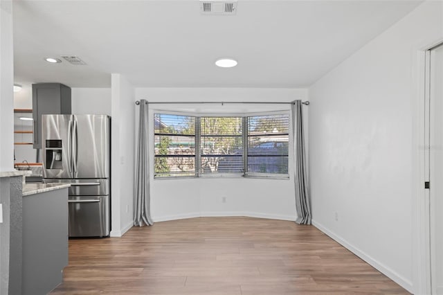 kitchen featuring light wood-style flooring, gray cabinets, visible vents, and stainless steel refrigerator with ice dispenser