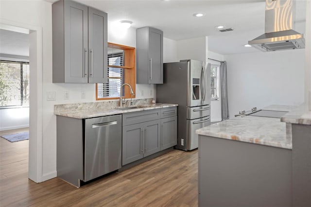 kitchen featuring appliances with stainless steel finishes, gray cabinetry, visible vents, and island range hood