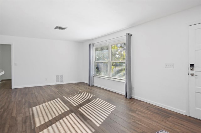 interior space featuring dark wood finished floors, visible vents, and baseboards