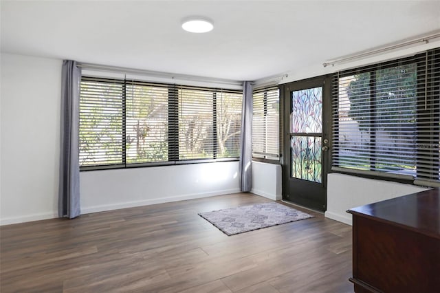 interior space featuring dark wood-style flooring and baseboards