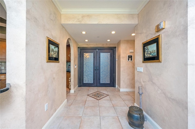 foyer entrance featuring light tile patterned flooring, crown molding, and french doors