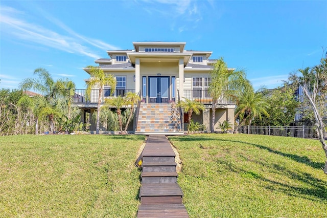 view of front of property featuring fence, stairway, and a front lawn