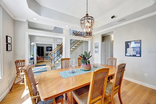 dining space with light wood-style flooring, visible vents, stairway, and baseboards