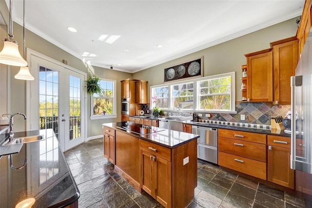 kitchen featuring brown cabinetry, appliances with stainless steel finishes, a center island, french doors, and a sink