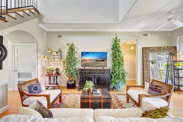 living room with crown molding, visible vents, and wood finished floors