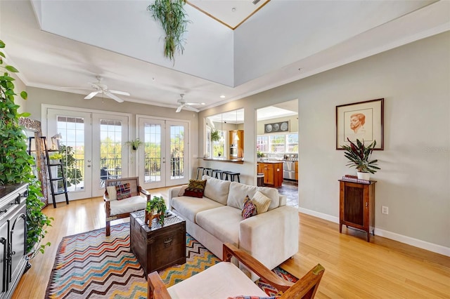 living area featuring light wood finished floors, baseboards, ornamental molding, and french doors