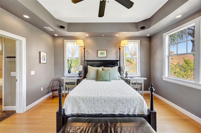 bedroom with light wood finished floors, visible vents, and baseboards