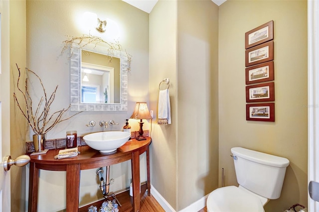 bathroom featuring a sink, toilet, and baseboards