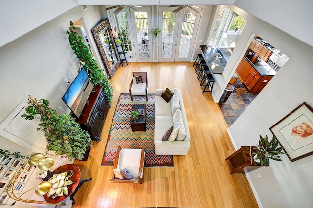 living area with french doors, wood finished floors, and a ceiling fan