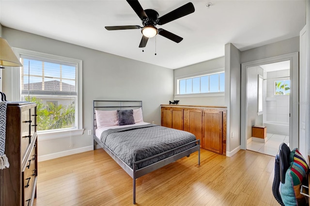 bedroom with baseboards, multiple windows, and light wood finished floors