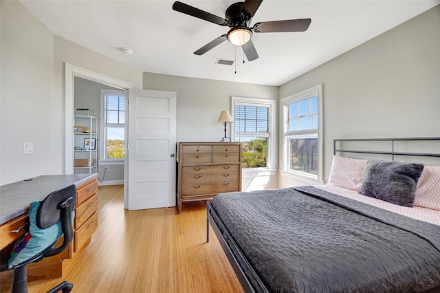 bedroom with light wood-type flooring, visible vents, and a ceiling fan